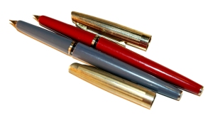 Vintage fountain pens - one gray, one red; both with gold caps.