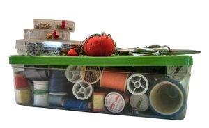 A clear plastic shoebox with a variety of sewing supplies.